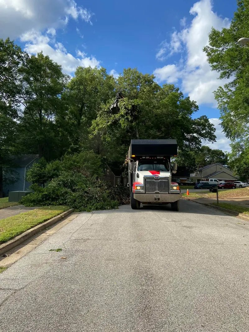 Dump truck hauling debris out of a neighborhood street